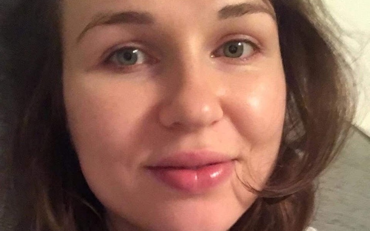 Portret kobiety z naturalnym makijażem i uśmiechem.