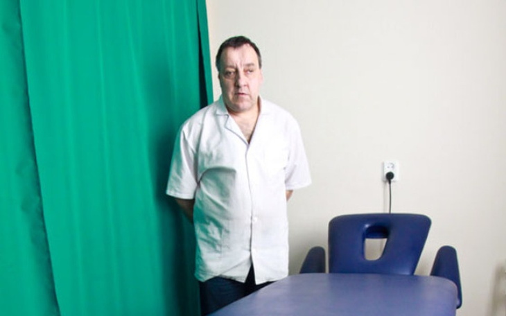 Mężczyzna w białej koszuli w pomieszczeniu.