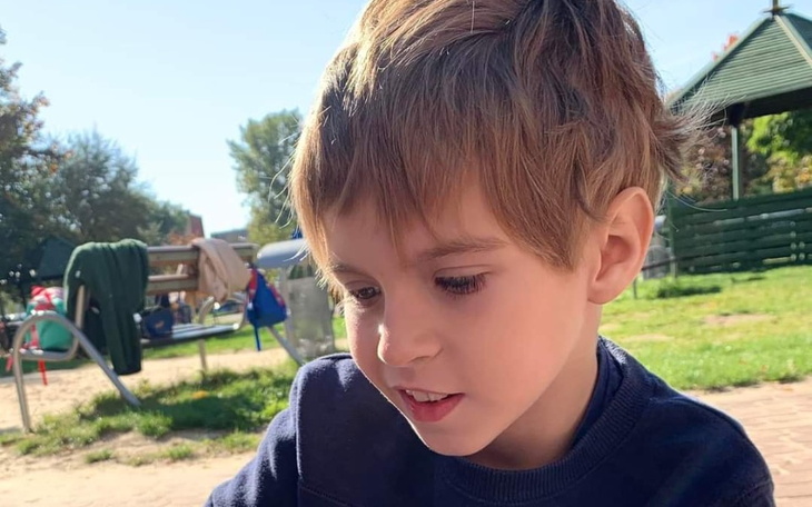 Chłopiec bawiący się na placu zabaw w słoneczny dzień.