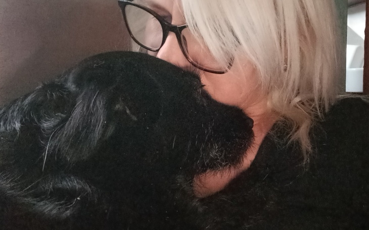 Kobieta przytulająca psa, chwila bliskości.