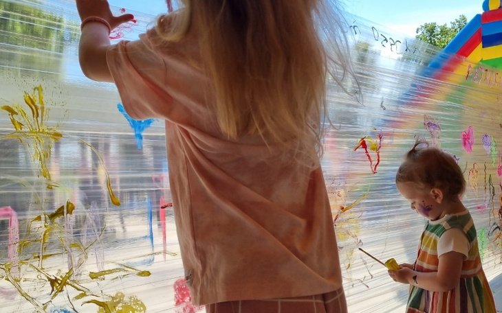 Dzieci malujące na przezroczystej folii, kreatywna zabawa.