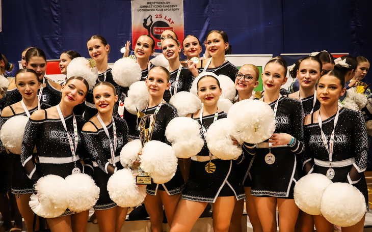 Grupa dziewcząt w strojach sportowych z nagrodami.