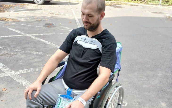 Mężczyzna na wózku inwalidzkim w parku.