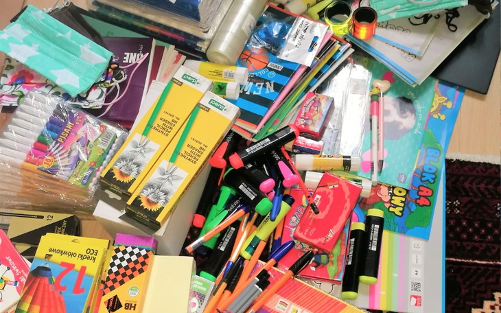 Zestaw przyborów szkolnych i artystycznych na stole.