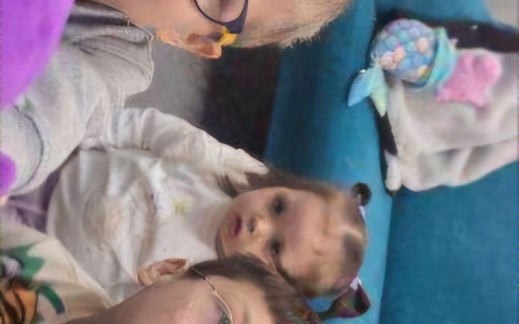 Dzieci bawiące się na kanapie, z uśmiechami na twarzach.