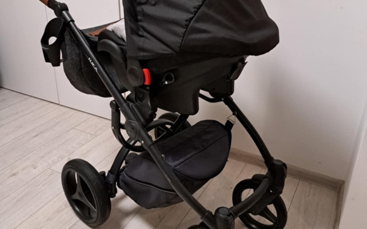 Wózek dziecięcy w kolorze czarnym, widok z boku.