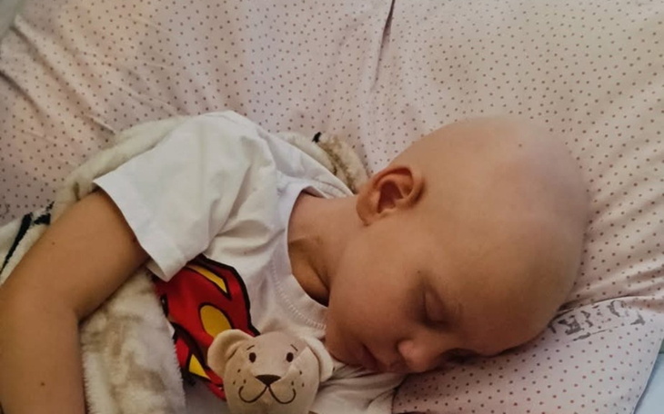 Mały chłopiec śpiący z pluszowym misiem, bez włosów.