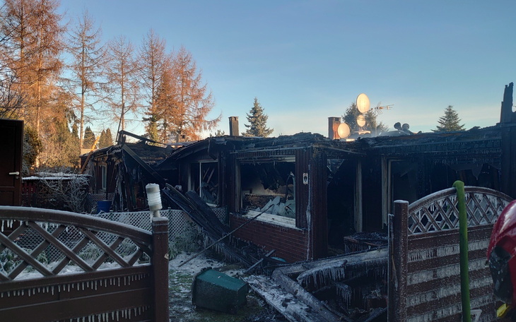 Zniszczony budynek po pożarze, z widocznymi zniszczeniami.