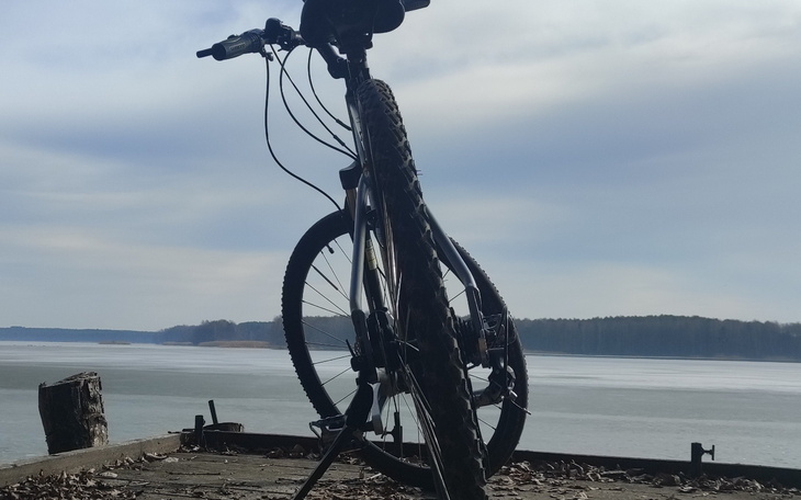 Rower stojący na pomoście, z widokiem na jezioro.