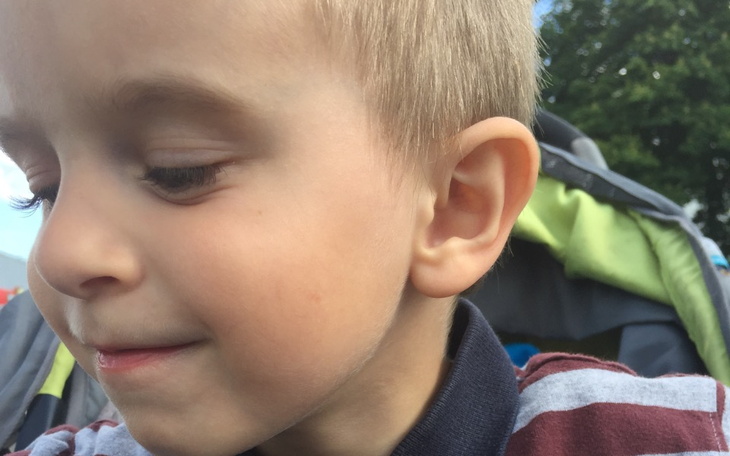 Chłopiec z uśmiechem, bawiący się na świeżym powietrzu.