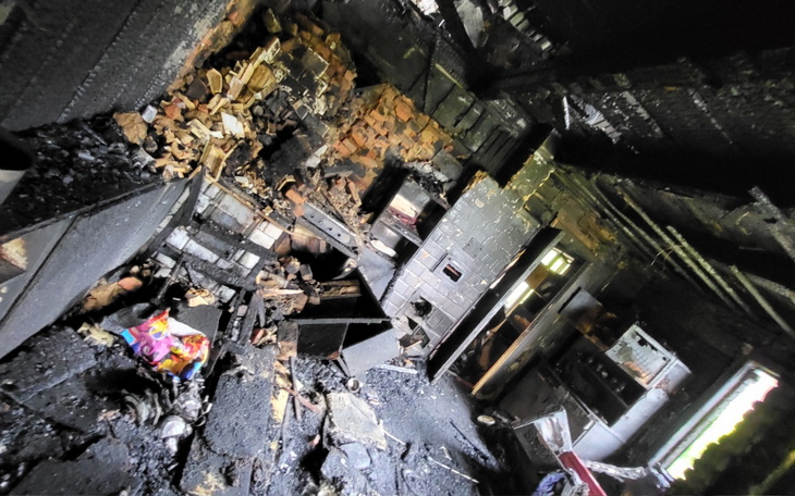Zniszczone wnętrze domu po pożarze, pełne popiołu.