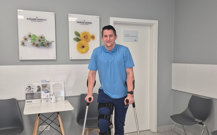 Mężczyzna na kulach, w rehabilitacyjnym otoczeniu.