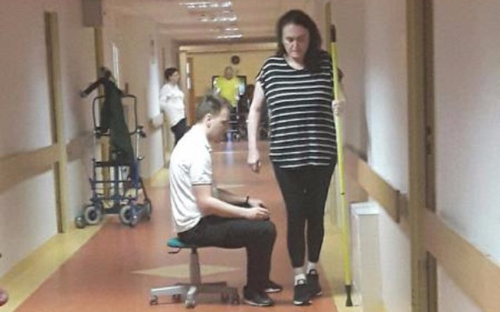 Rehabilitacja w szpitalu, pacjent ćwiczy z pomocą terapeuty.