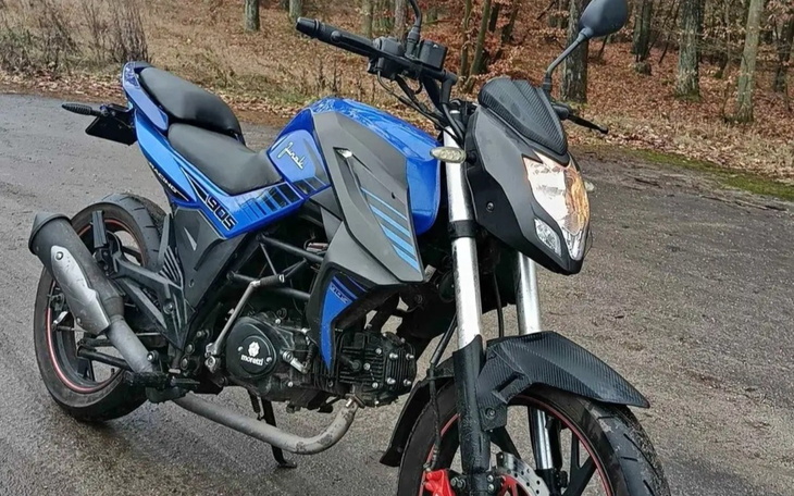 Motocykl na leśnej drodze w otoczeniu przyrody.