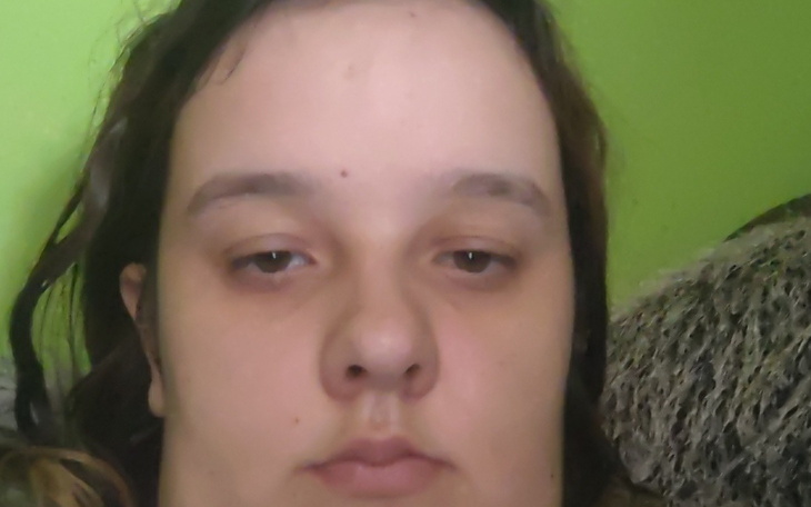 Portret młodej kobiety z wyrazem twarzy.