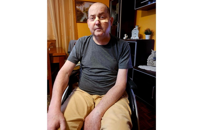 Mężczyzna w wózku inwalidzkim, siedzący w domu.