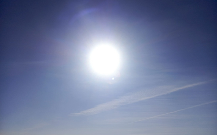 Jasne słońce na błękitnym niebie, symbolizujące piękny dzień.