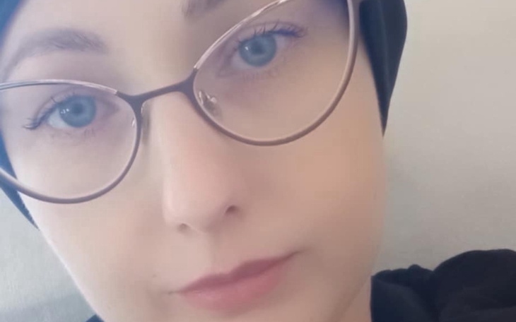 Portret kobiety w okularach, z jasnymi oczami i chustą.