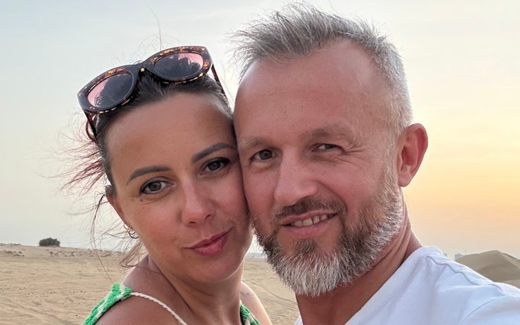 Para na tle zachodzącego słońca, uśmiechnięta i bliska sobie.