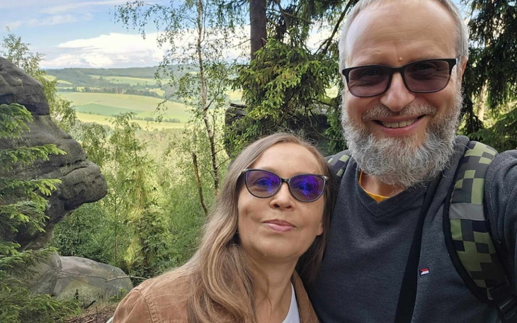 Para na tle malowniczej scenerii górskiej, uśmiechająca się do kamery.