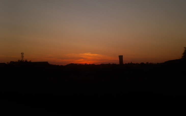 Zachód słońca nad horyzontem, z ciepłymi odcieniami nieba.