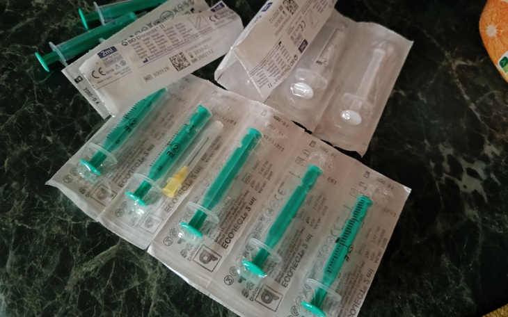 Zestaw strzykawek i materiałów medycznych na stole.