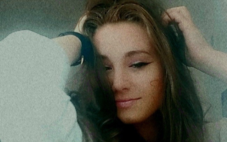 Młoda kobieta z długimi włosami, w stylowej pozie.