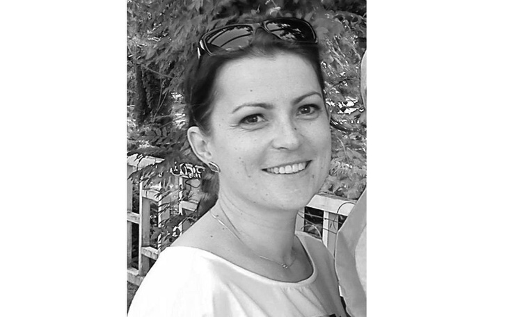 Portret uśmiechniętej kobiety w okularach przeciwsłonecznych.