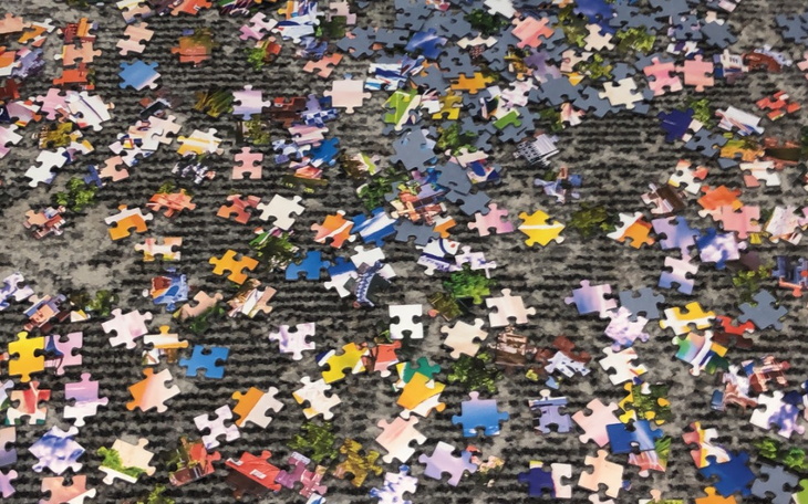 Rozrzucone kawałki puzzli na podłodze.