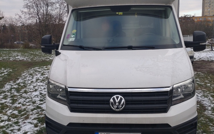 Biały samochód dostawczy zaparkowany na śniegu.