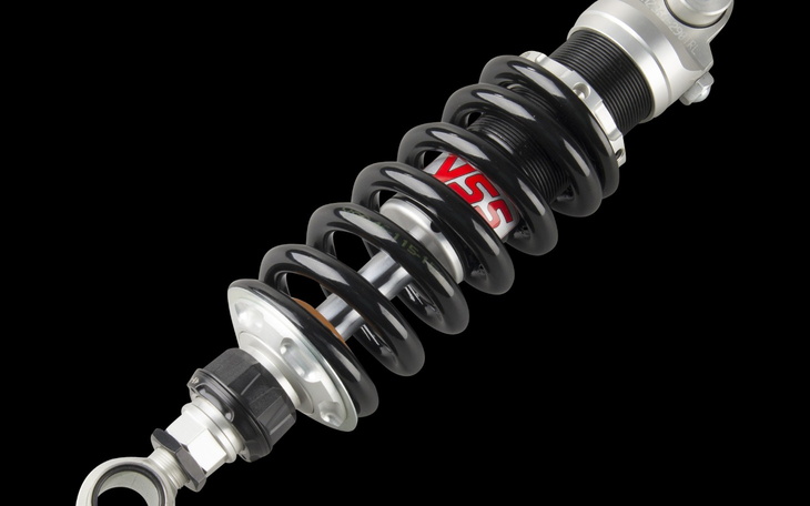 Amortyzator samochodowy z czarną sprężyną.