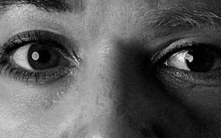 Zbliżenie na oczy osoby, z wyraźnym kontrastem światła i cienia.