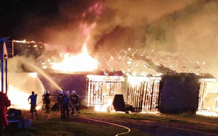 Pożar budynku, strażacy walczą z ogniem.