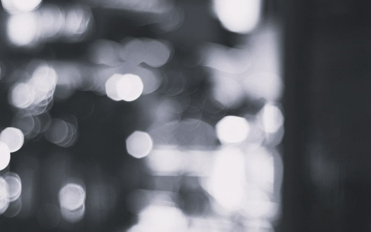 Abstrakcyjny obraz w odcieniach szarości z rozmytymi światłami.