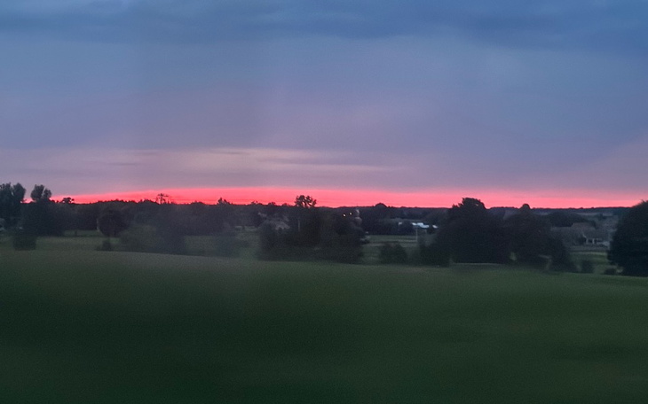 Malowniczy zachód słońca nad zielonymi polami.