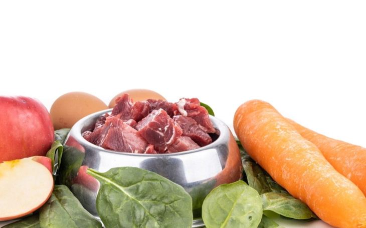 Miska z surowym mięsem i warzywami, idealna dla zdrowego posiłku dla zwierząt.