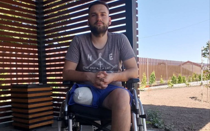 Mężczyzna na wózku inwalidzkim, siedzący na tarasie.