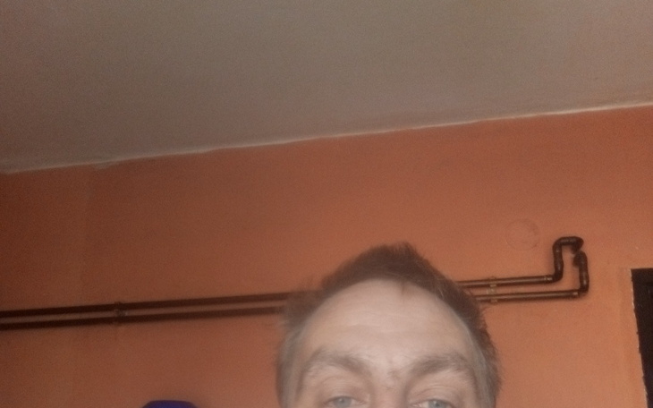 Osoba w pomieszczeniu z widoczną ścianą i rurami.