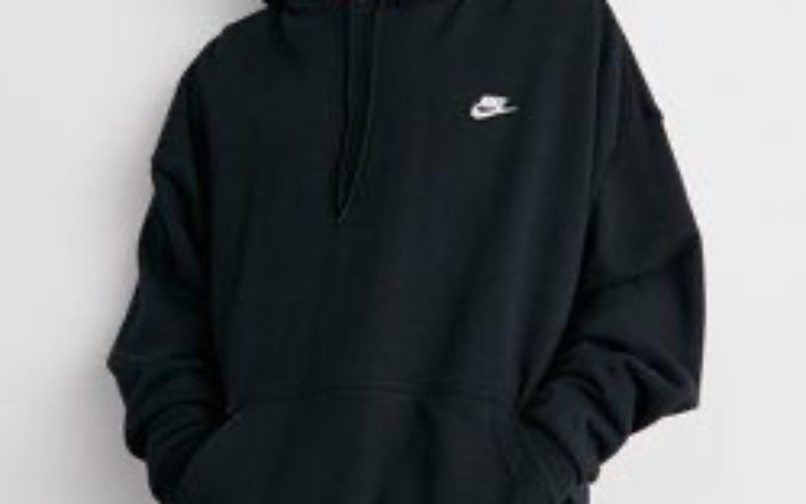 Osoba w czarnej bluzie z kapturem marki Nike.