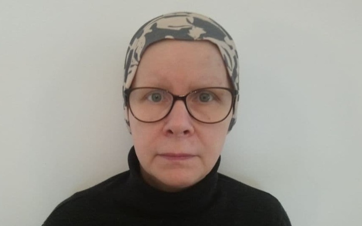 Kobieta w chustce, patrząca prosto w obiektyw.