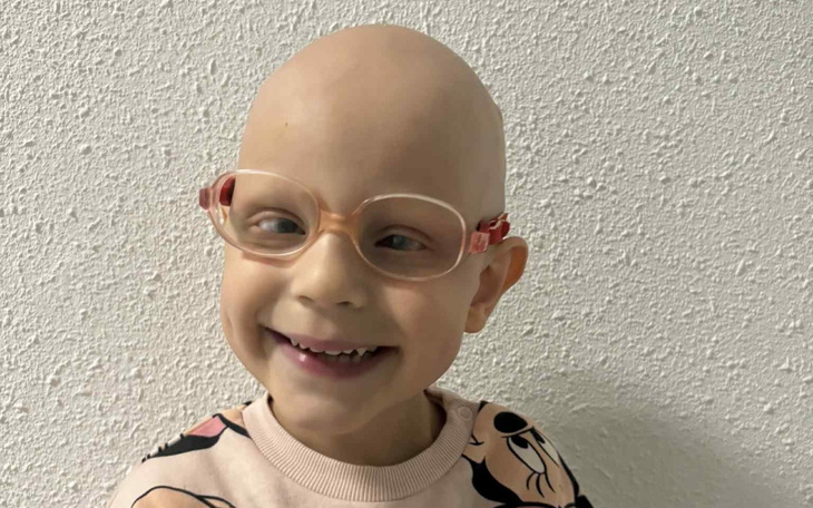 Chłopiec z okularami, uśmiechający się.