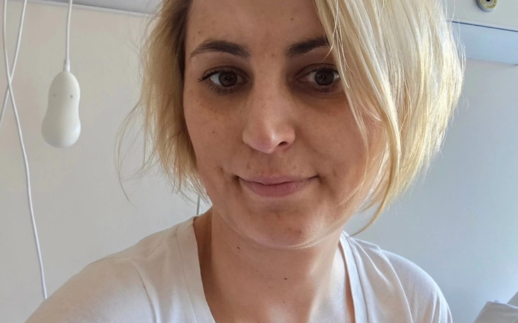 Kobieta z krótkimi włosami, selfie w jasnym pomieszczeniu.