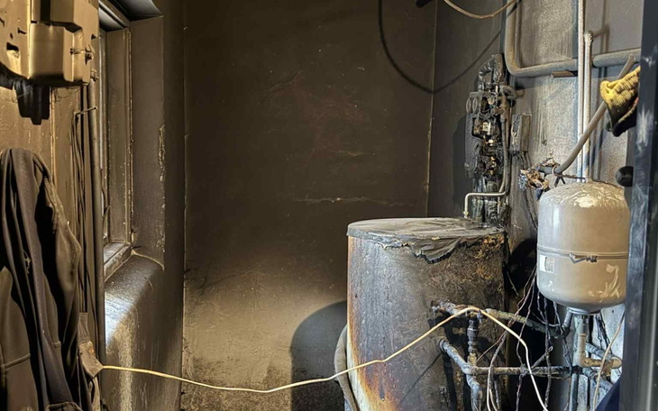 Zniszczona przestrzeń z rurami i urządzeniami technicznymi.