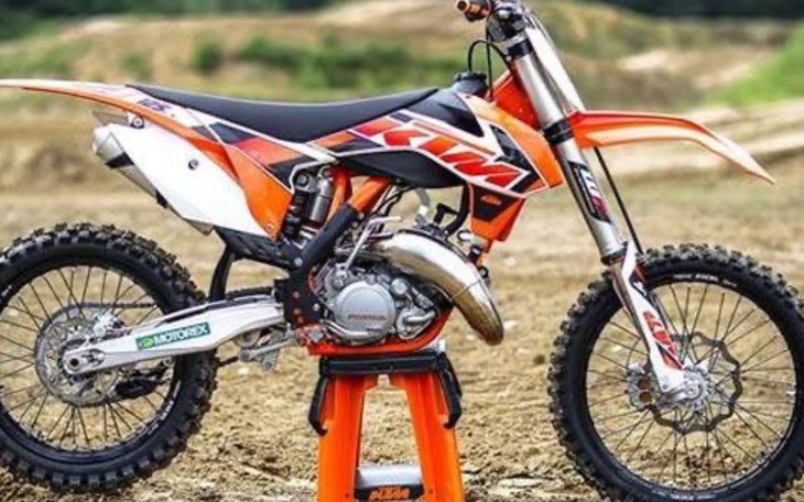 Motocykl KTM na stojaku, gotowy do jazdy.