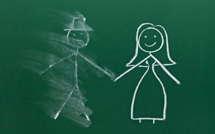 Rysunek kredą na tablicy, przedstawiający parę trzymającą się za ręce.