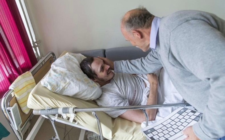 Mężczyzna z poważnym wyrazem twarzy, patrzący w obiektyw.