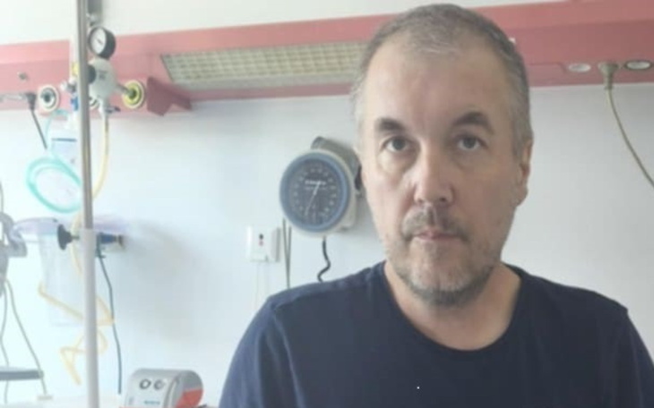 Mężczyzna w szpitalu, z poważnym wyrazem twarzy.