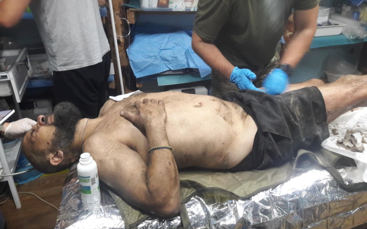 Mężczyzna leżący na stole, podczas zabiegu medycznego.