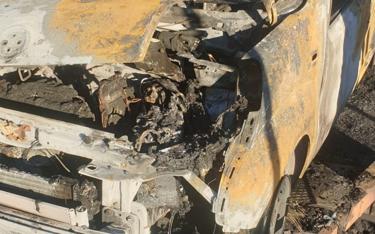 Zniszczony samochód po pożarze, widoczne uszkodzenia i spalone elementy.