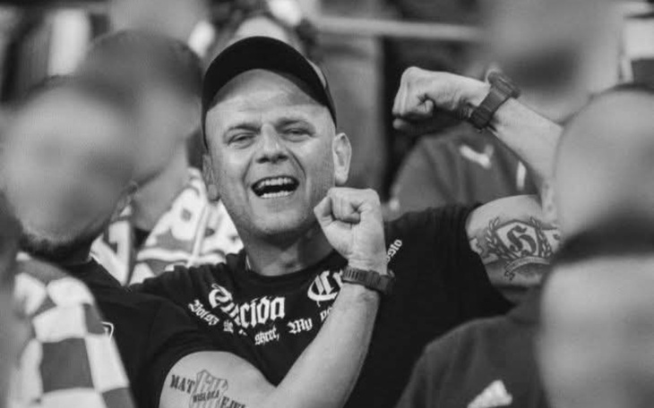 Mężczyzna w tłumie, cieszy się i pokazuje mięśnie.